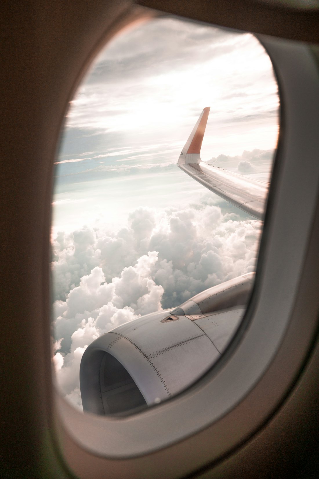 Utsikt genom ett flygplansfönster över molnen